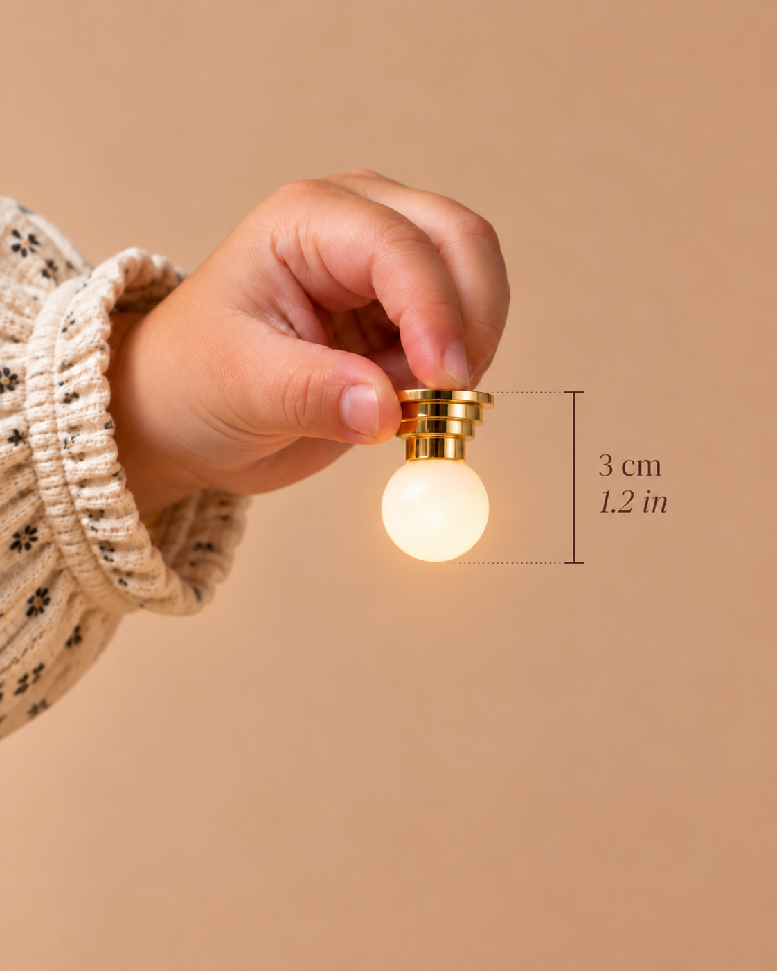 A 3 cm (1.2 in) miniature gold light with a softly glowing frosted globe, designed for tables, bedside settings and 1:12 scale interiors.