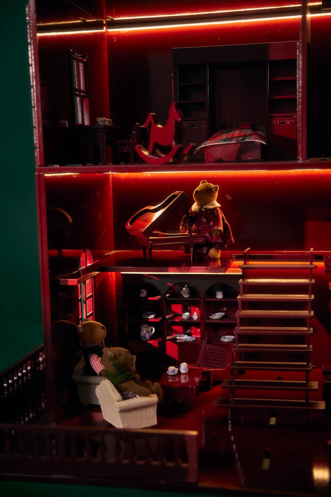 Luxury handcrafted wooden dollhouse in Bordeaux red with miniature teddy bears and LED lighting, limited-edition collectible by Little Forest Animals, blending art, nostalgia and quiet luxury décor.