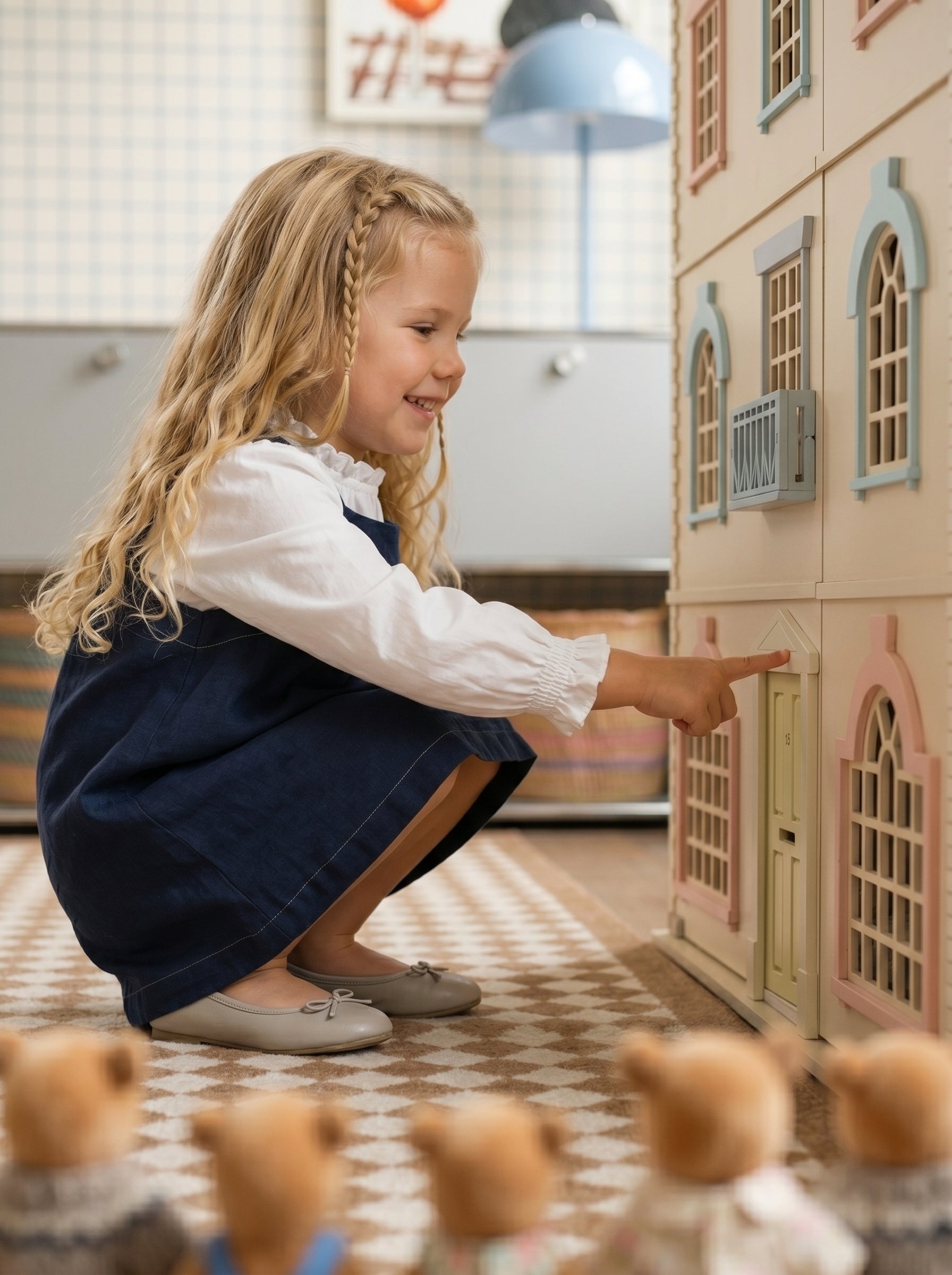 Child opening the front door of the House of London wooden dollhouse while Little Forest Animals doll figures watch nearby.