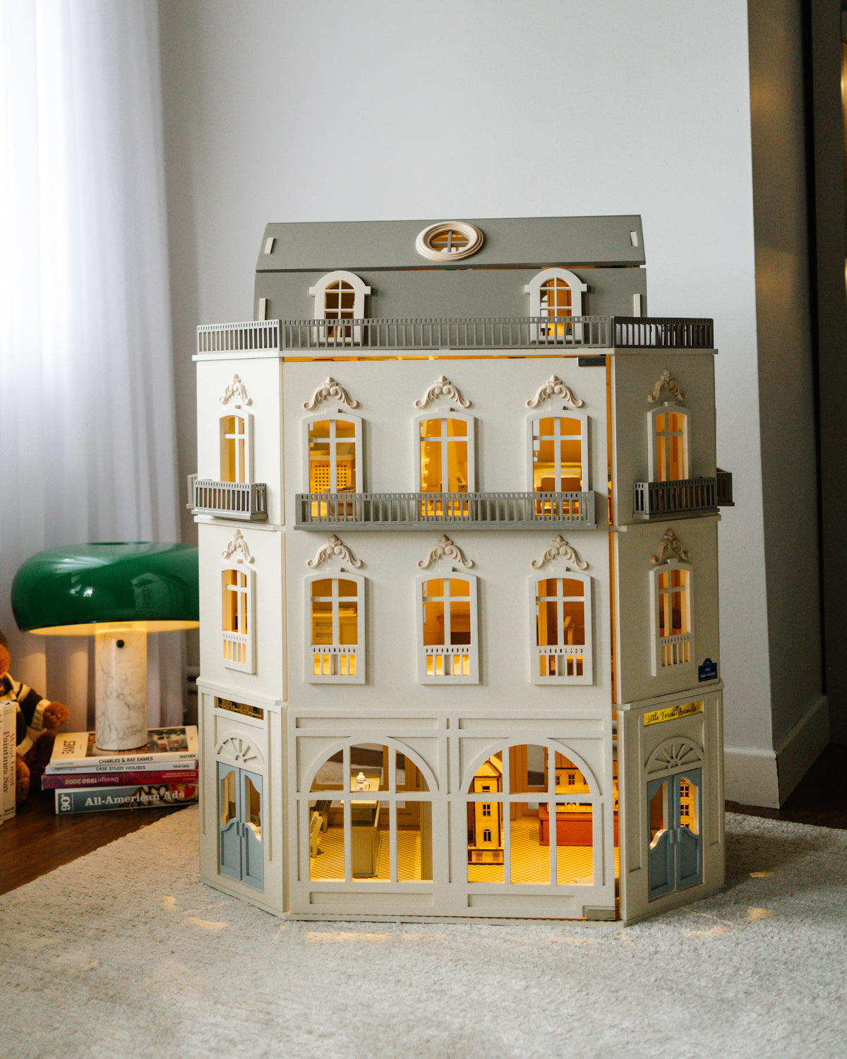 Full view of the House of Paris dollhouse with illuminated rooms and classic Parisian-inspired details.