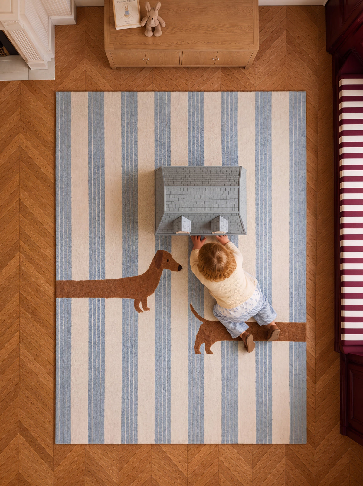 Overhead view of The Dachshund rug featuring soft blue stripes and a playful dachshund design.
