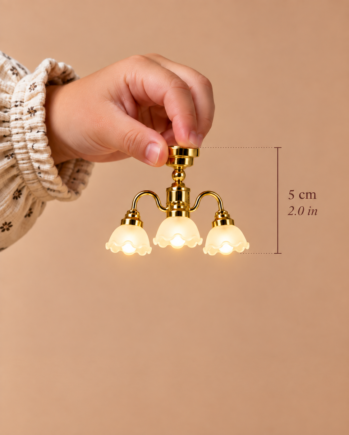 A 5 cm (2.0 in) three-arm gold chandelier with softly illuminated frosted shades, created to bring architectural lighting to miniature interiors.