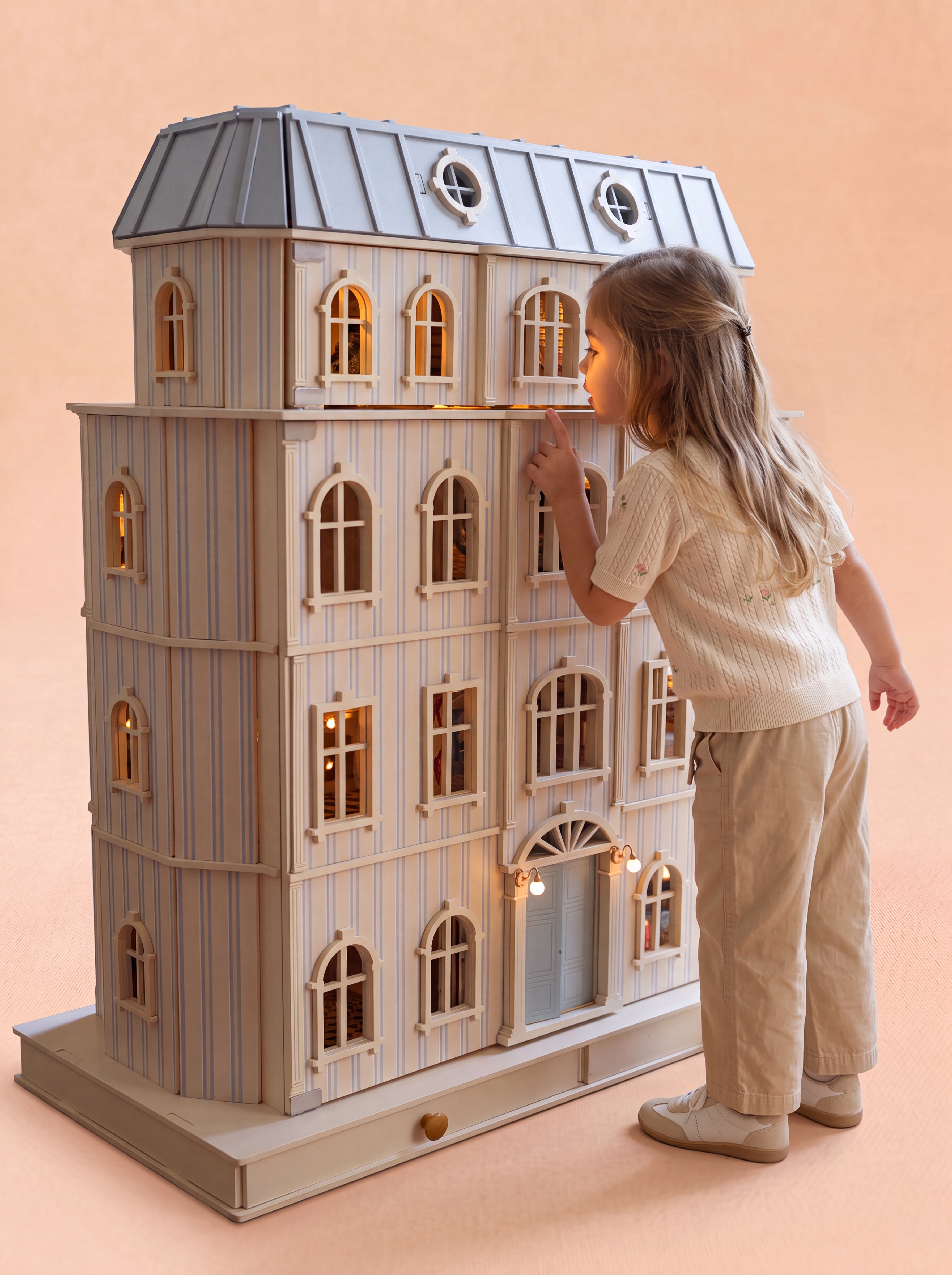 Girl looking through the arched windows of the House of Monaco luxury wooden dollhouse.