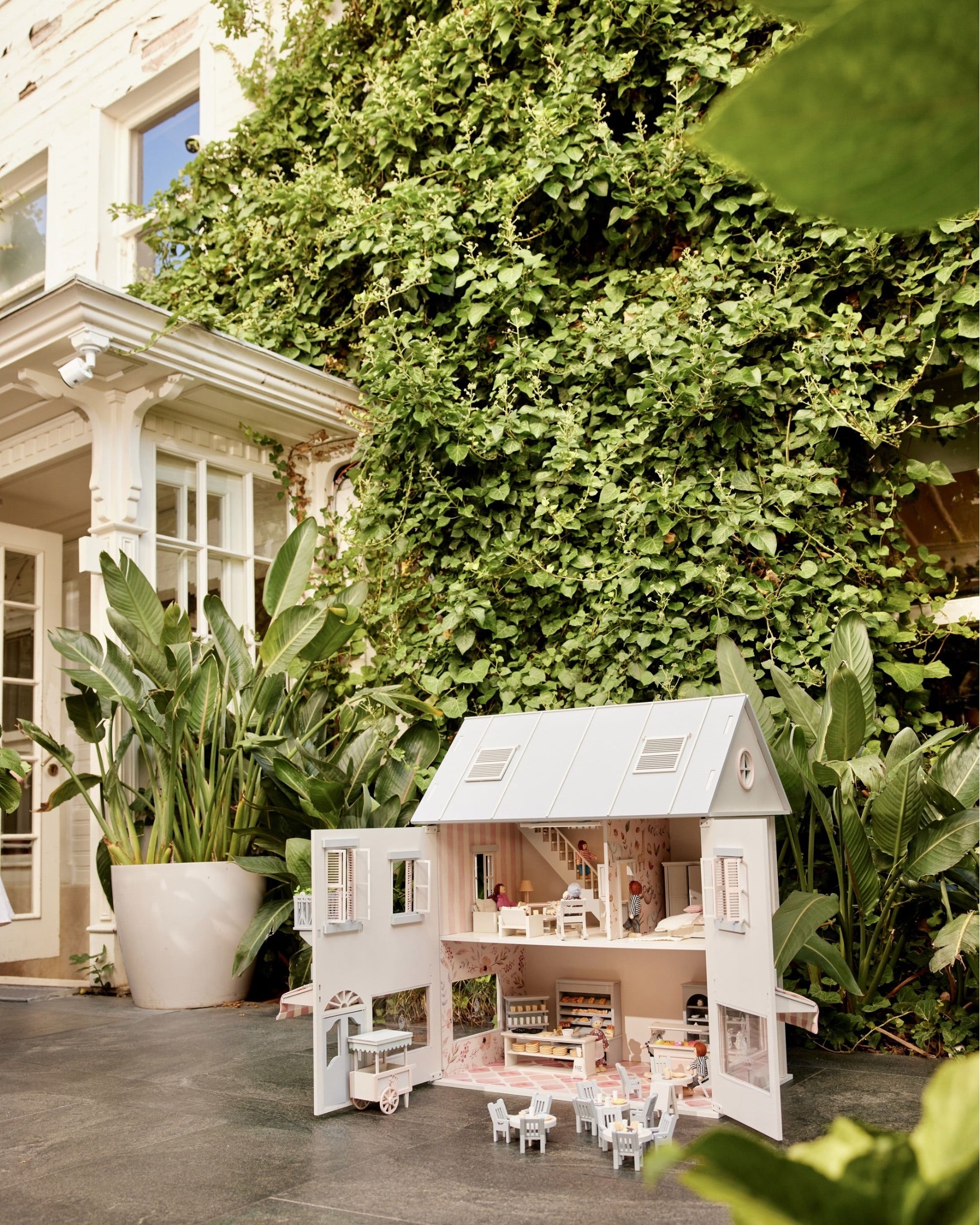 House of Rome café and bakery dollhouse in a garden scene with its miniature furnishings.