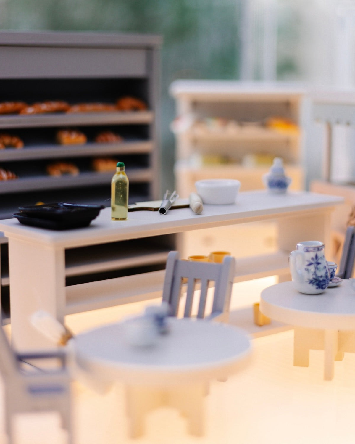 Miniature café counter with baking tools, porcelain tableware, and bread shelves inside the Crystal Rome Collector's Edition.