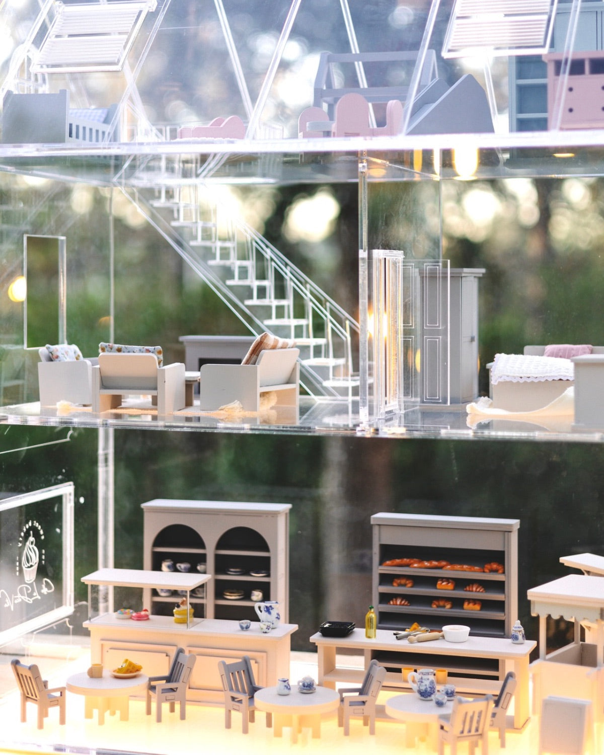Overview of the Crystal Rome Collector's Edition showing the miniature café, living room, staircase, and bedroom through the clear walls.