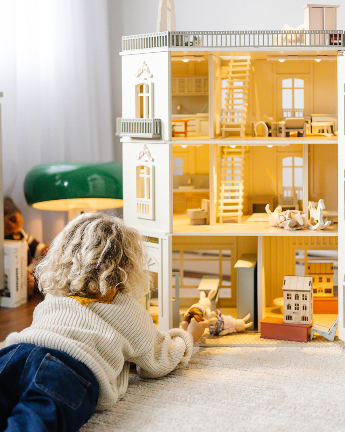 The open House of Paris dollhouse is shown during play with miniature figures placed inside.