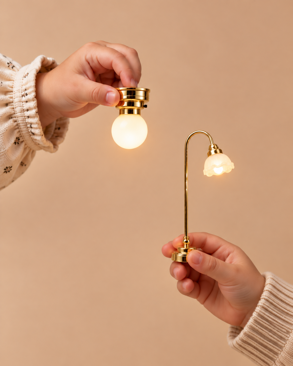 Hands holding a miniature brass globe lamp and floor lamp for dollhouses.