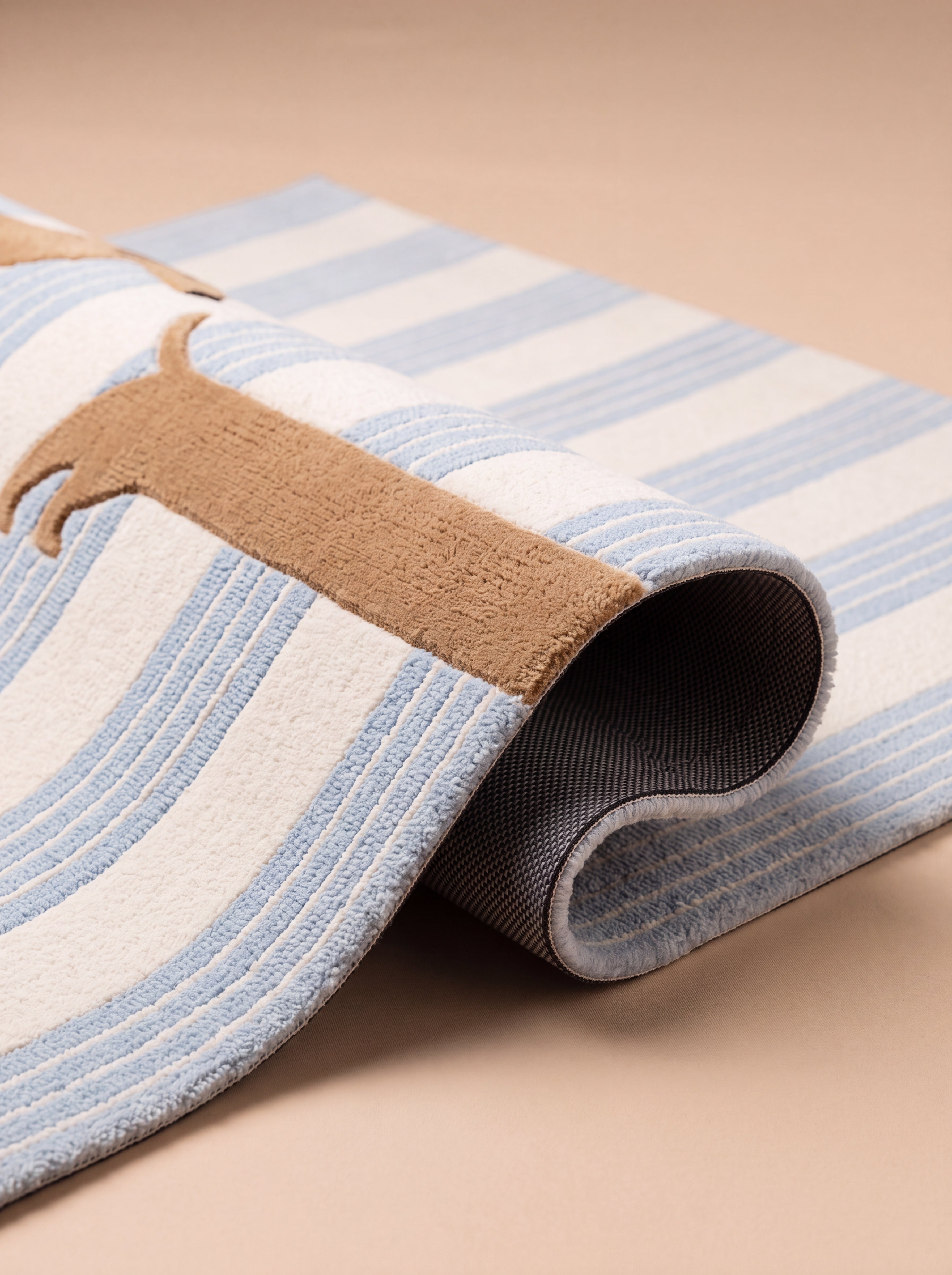 Close-up of a folded blue striped rug with a woven dachshund design, showing the textured surface and non-slip backing.