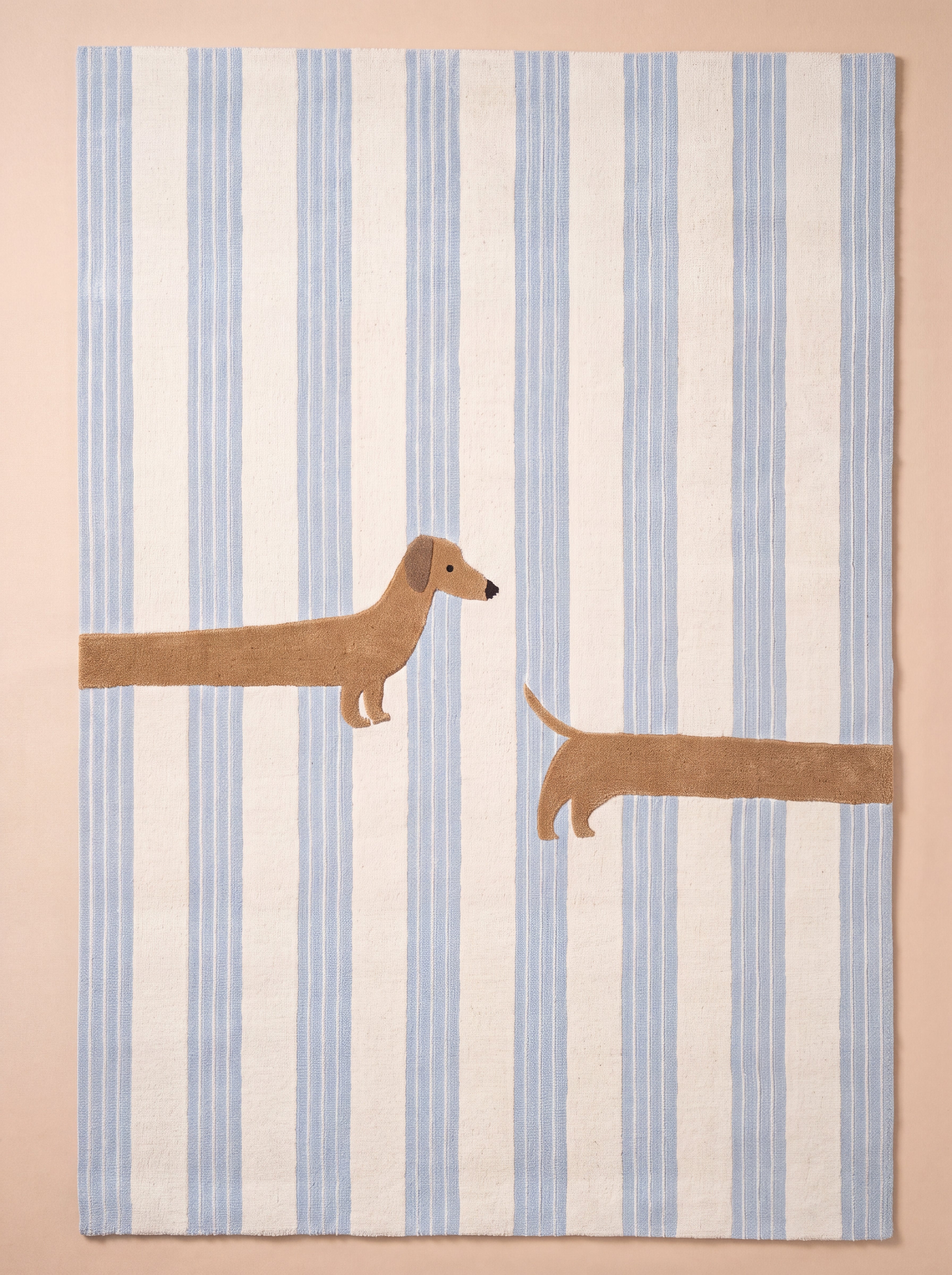 Full view of a blue striped rug with a woven dachshund design on a neutral background.