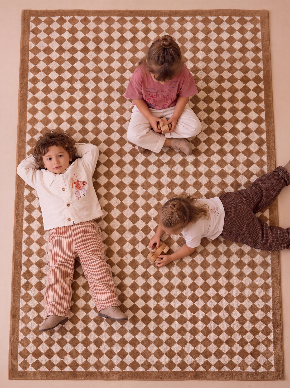 Children playing on The Diamond rug with a classic diamond pattern in a family playroom.